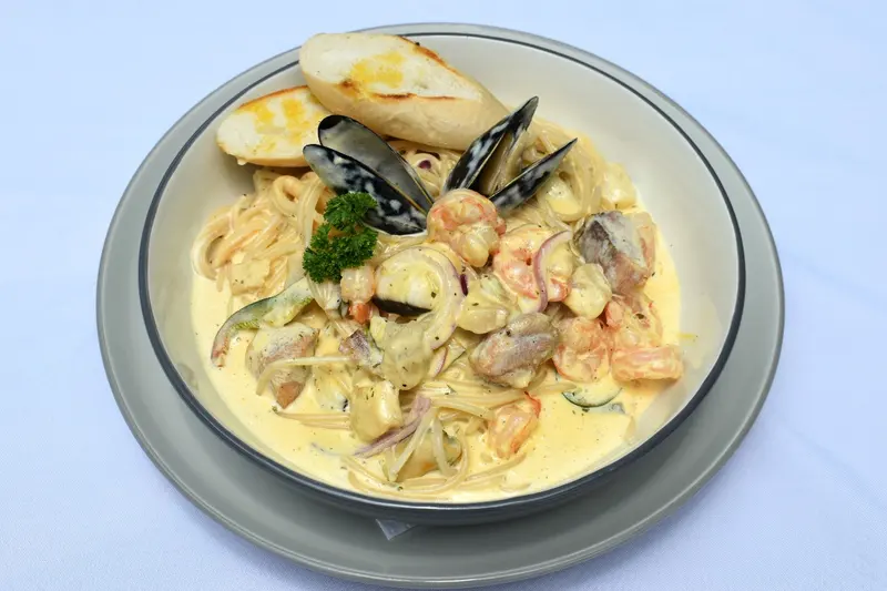 Pasta con camarones y mejillones en salsa blanca con pan tostado