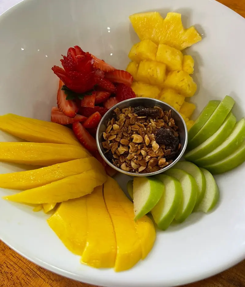 Bowl de frutas con mango, piña, fresas, manzana verde y granola