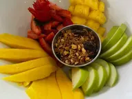Bowl de frutas con mango, piña, fresas, manzana verde y granola