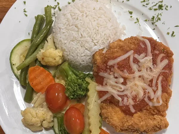 Pollo parmesano empanizado con salsa roja y queso, arroz y vegetales