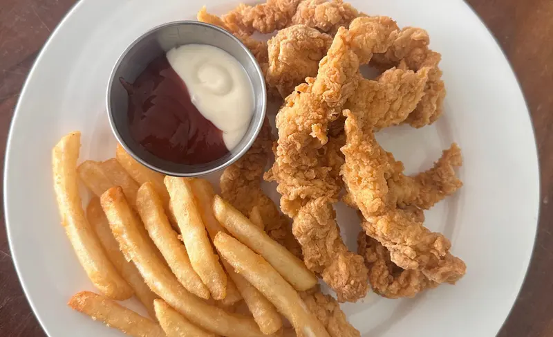 Dedos de pollo empanizados con papas fritas y salsas