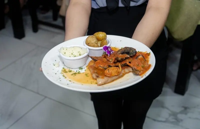 Pescado en salsa de tomate con papas y guarniciones