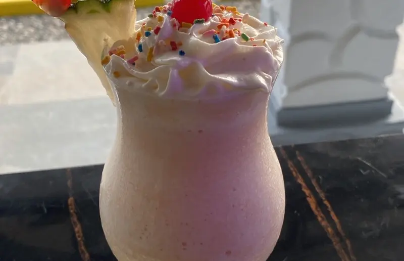 Batido rosado con crema batida y confites
